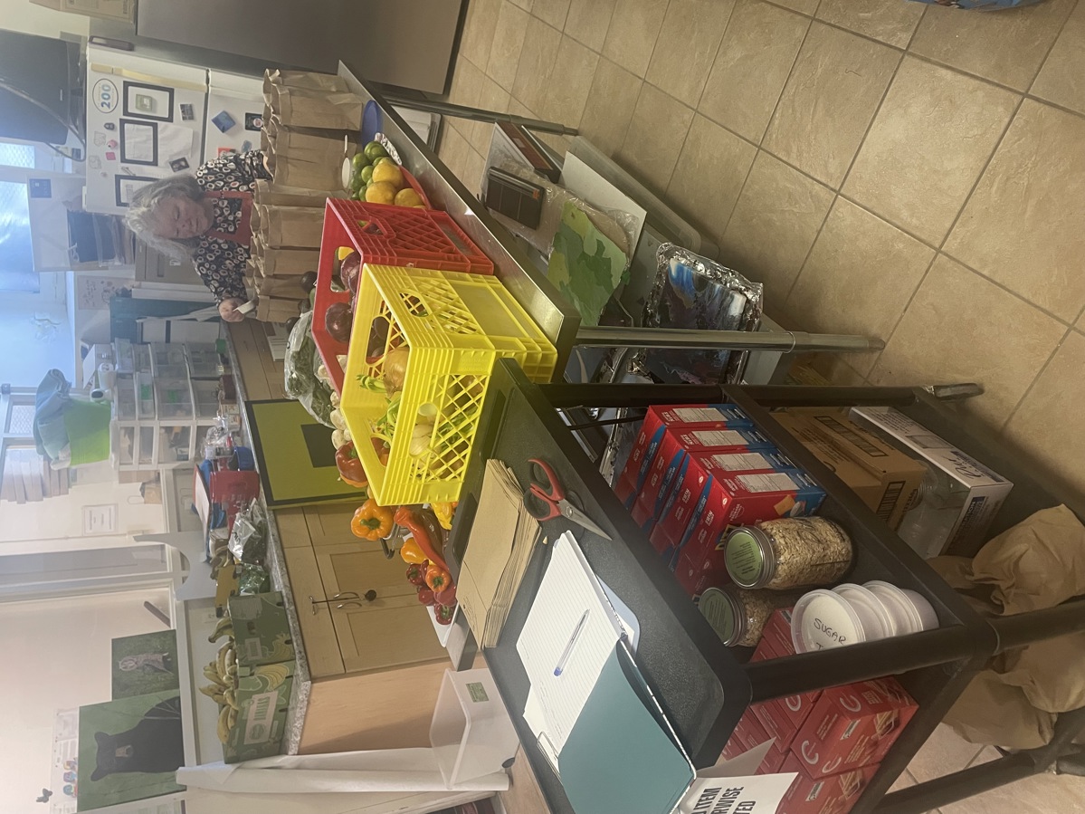 A volunteer organizing food at The Mess Studio food pantry.