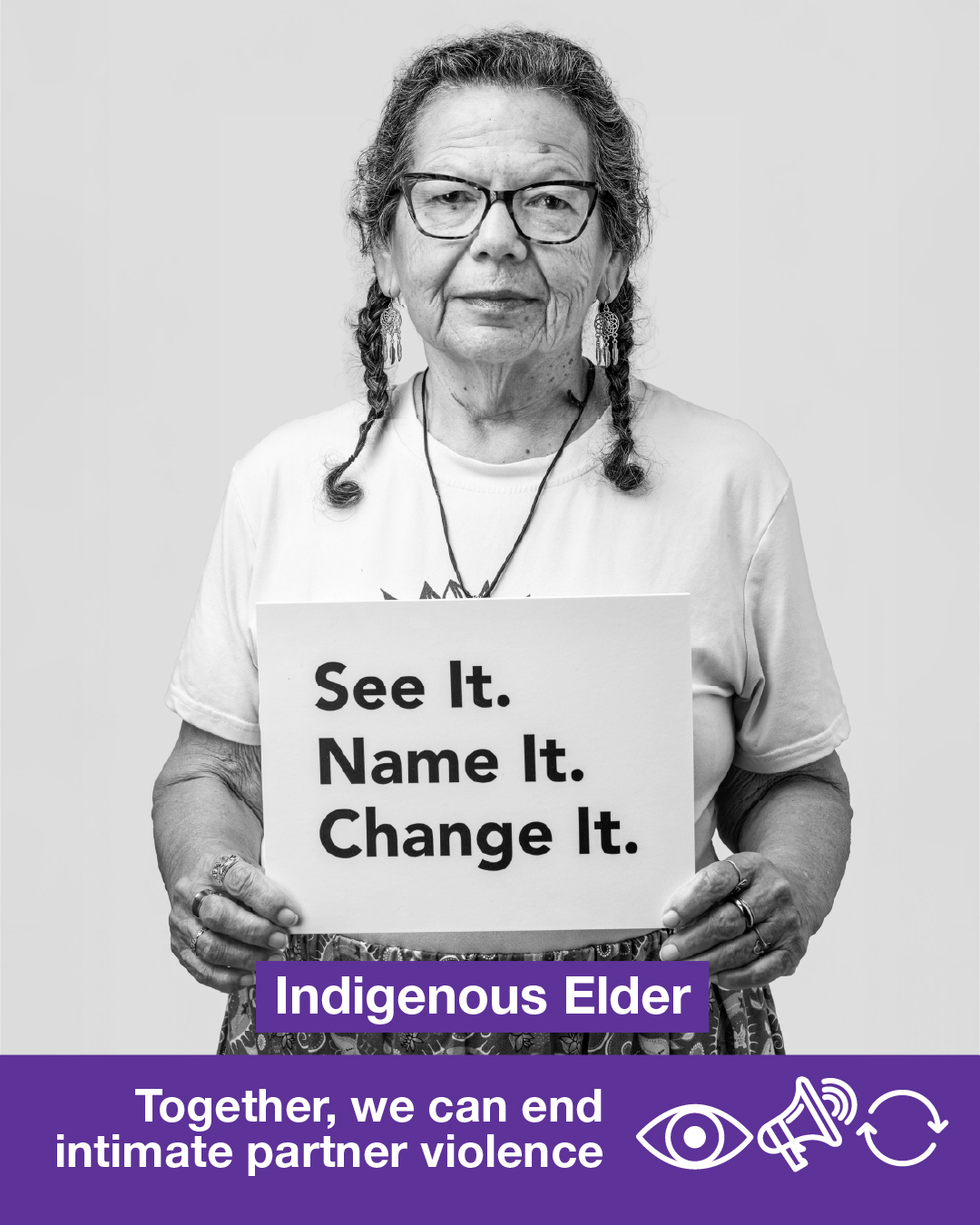 A black-and-white photo of an Indigenous elder holding a sign that says See It. Name It. Change It. Together, we can end intimate partner violence.