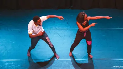 Two performers on stage dancing. Photo by Celine Klein.