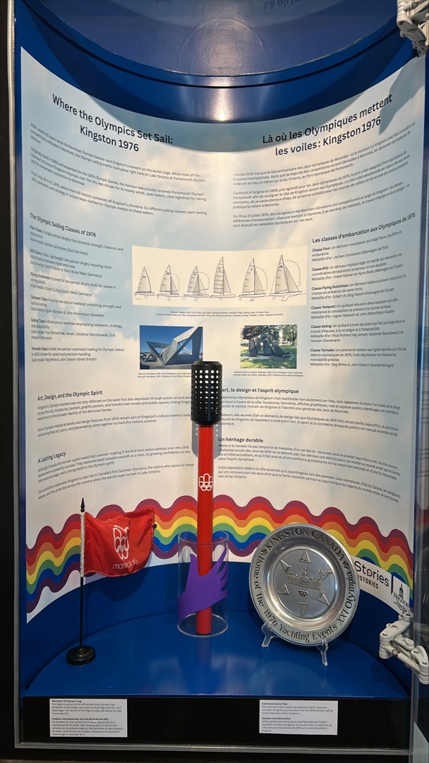 Exhibit space showcasing Kingston's Olympic history, featuring the Montreal 1976 Olympic flag and a commemorative plate.