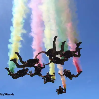 he SkyHawks, Canadian Armed Forces Parachute Team in airborne formation with coloured smoke trailing behind them