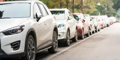 A row of cars parked on the side of a street